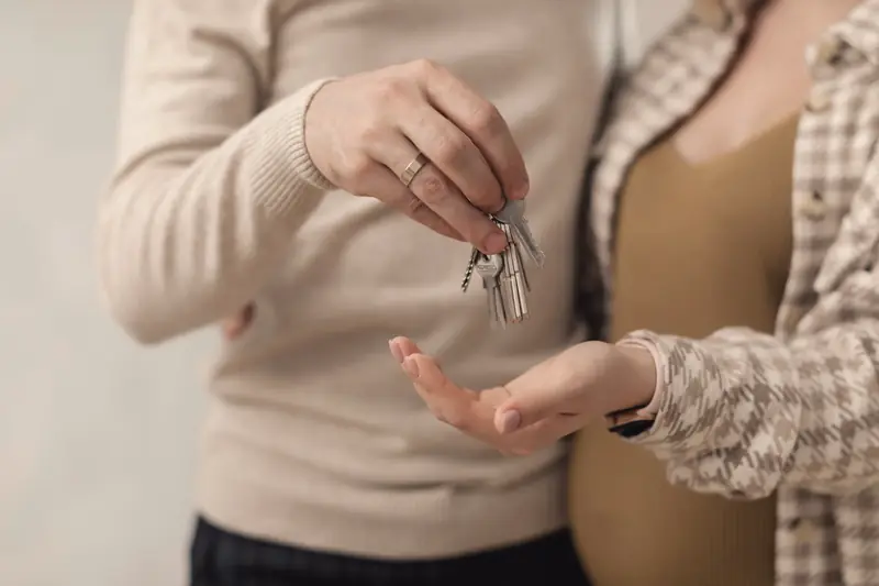 Two people handing over house keys